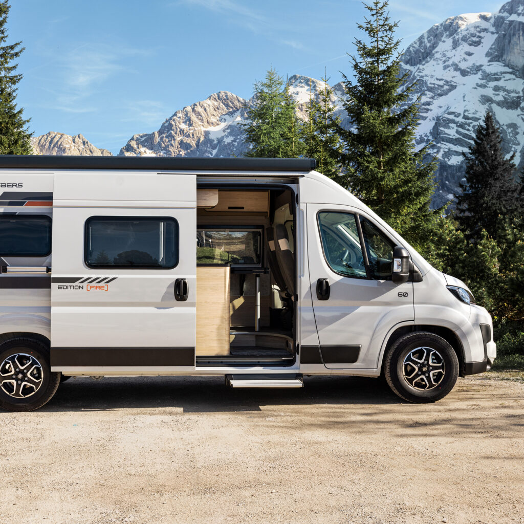 Vit campervan från Weinsberg med öppen skjutdörr, parkerad i en bergsmiljö